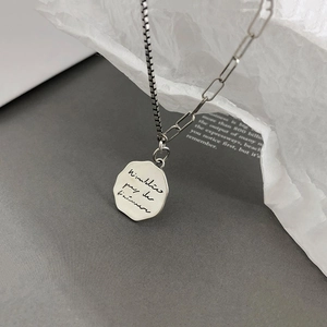 Detail of s925 silver irregular pendant necklace with engraved script and asymmetric chains