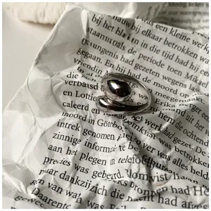 Macro shot of minimalist S925 silver wide ring with irregular liquid metal wrap texture