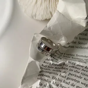 Minimalist double-layer S925 silver open ring with polished finish on artistic background