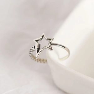 Minimalist silver pentagram ring with woven band texture on white ceramic display