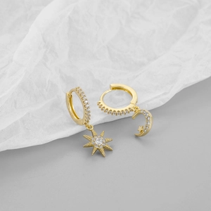 Detailed macro of S925 sterling silver stamp on gold star and moon asymmetrical earrings