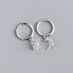Detail of silver star and moon drop earrings with sparkling pavé cubic zirconia