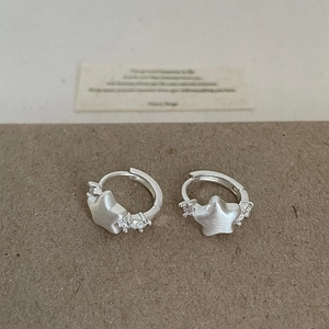 Macro shot of silver star-shaped hoop earrings with matte finish and pavé cubic zirconia