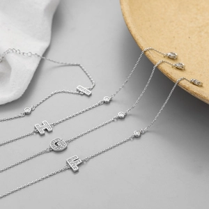 Minimalist silver chain bracelets with micro-pave zircon initial letters I, H, G, and F