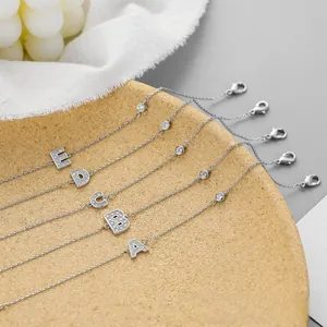Macro detail of silver initial bracelets A-E with micro-pave crystals and lobster clasp