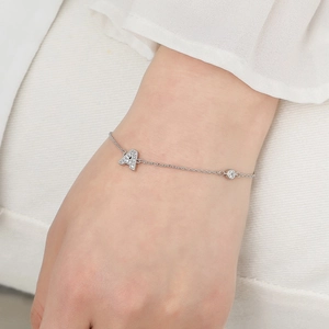Elegant silver micro-pave zircon initial A bracelet on wrist against soft fabric