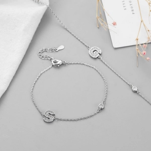 Detail of silver letter S and G charms with micro-pave cubic zirconia on a delicate chain