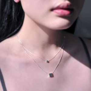 Detailaufnahme einer doppelreihigen 925 Silberkette mit geometrischen Würfelanhängern