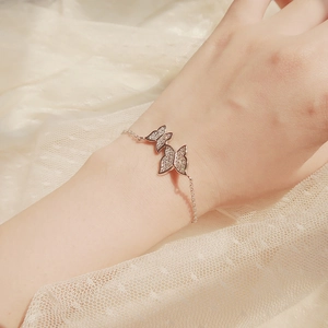 Close-up of a silver butterfly bracelet with pave-set zircon on soft lace fabric