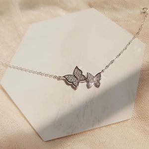 Silver butterfly bracelet with sparkling cubic zirconia on white marble display