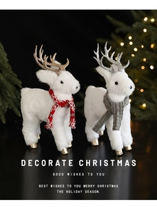 Detailed close-up of plush white Christmas reindeer figures with sequined antlers and cozy scarves