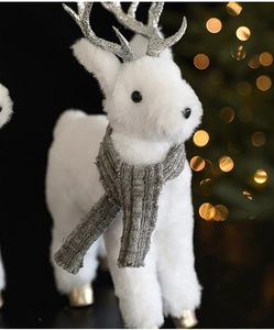 Detail of white plush reindeer with silver antlers and a grey knitted scarf for Christmas