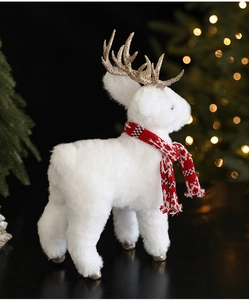 Detailed view of white plush reindeer decoration with gold glitter antlers and red knit scarf