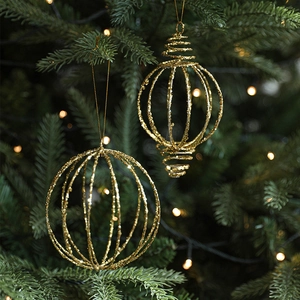 Sparkling gold Christmas ball pendants with glitter finish on a festive tree branch