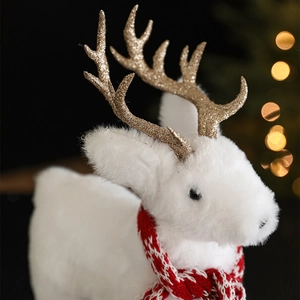 White plush Christmas reindeer figurine with gold glitter antlers and red knit scarf