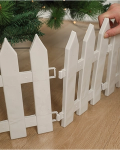 Detail of white plastic Christmas tree fence panels showing snap connection on wood floor