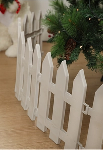 Detailed view of white plastic decorative fence panels around a Christmas tree base