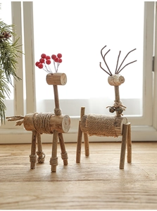 Makroansicht handgefertigter Holzrentiere mit Beeren und Glöckchen für Weihnachten