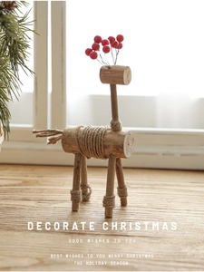 Detail der Weihnachts-Rentier-Deko aus Holz mit roten Beeren und Kordel auf dem Tisch
