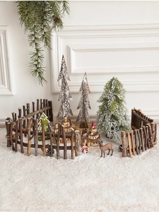 Close-up of wooden Christmas fence with miniature deer, snowman and pine trees decor