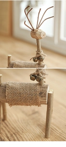 Detail einer handgefertigten Rentierfigur aus Holz mit Hanfseil und kleinen Messingglocken