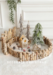 Close-up of wooden Christmas miniature set with glowing LED house and white birch fence