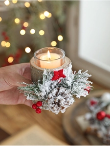 Macro detail of Christmas candle holder with natural pine cones and frosted snow effects