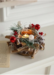 Macro detail of Christmas candle holder with snowy pine cones, berries and glass cup