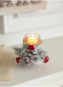 Close-up of rustic Christmas candle holder with pine cones berries and faux snow