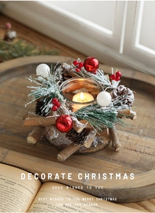 Close-up of a festive Christmas candle holder with snowy pine needles and red berries