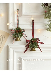Detail of vintage bronze Christmas bells with pine cones and red plaid bow decoration