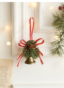 Detail of bronze metal bell with pine cones, needles, and a striped ribbon bow