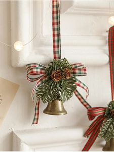 Macro detail of bronze bell with pine cones and checkered bow festive hanging decor