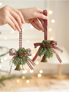 Close-up of bronze metal bells with pine cones and red-green plaid ribbon bows