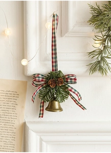 Detail of bronze bell with pine cones, needles, and a red plaid bow for festive decor
