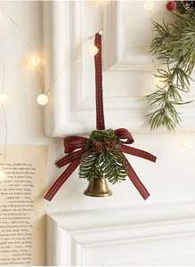 Detail of Christmas bell ornament with red plaid bow, pine needles and small pinecones