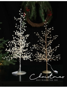 Detail of Christmas tree ornaments with silver pearls, gold crystals, and LED lighting