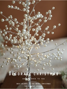 Close-up of LED pearl Christmas tree branch with warm lights and silver metal wire