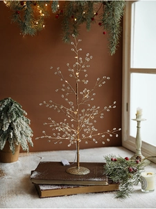 Close-up of lighted acrylic crystal Christmas tree branches with warm white LED lights