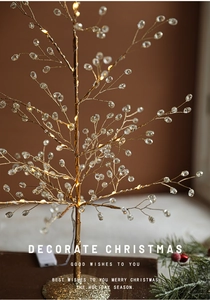 Macro view of crystal Christmas tree with warm LED lights and elegant golden base