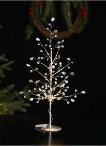 Macro shot of an acrylic crystal Christmas tree with LED lights and glowing beads