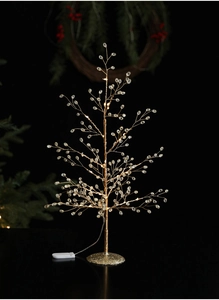 Macro view of crystal bead branches on a light-up Christmas tree with warm LED glow