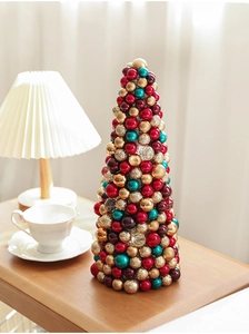 Close-up of a 35cm cone Christmas tree made of colorful red, gold, and green ornaments