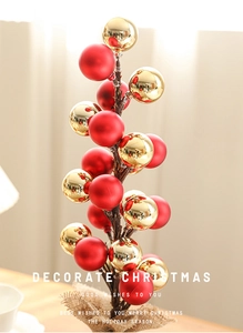 Detailed view of matte red and glossy gold Christmas ball ornaments on a realistic tree branch