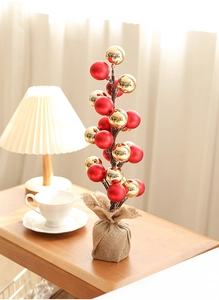 Detail of red and gold festive ball ornaments on a 35cm tree tower with burlap base