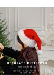 Close-up of classic red Christmas hat with white plush trim and fuzzy pom-pom detail