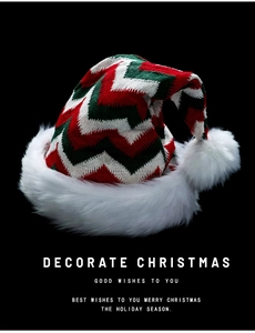 Close-up of red and green zigzag knit Christmas hat with soft white faux fur trim