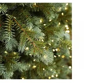 Macro shot of dense artificial pine needles with warm LED lights on a luxury Christmas tree