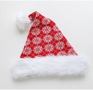 Detail of red knit Christmas hat with white snowflake patterns and plush faux fur trim