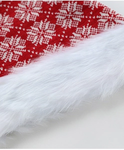 Close-up of red knit Christmas hat with white snowflake patterns and plush faux fur trim